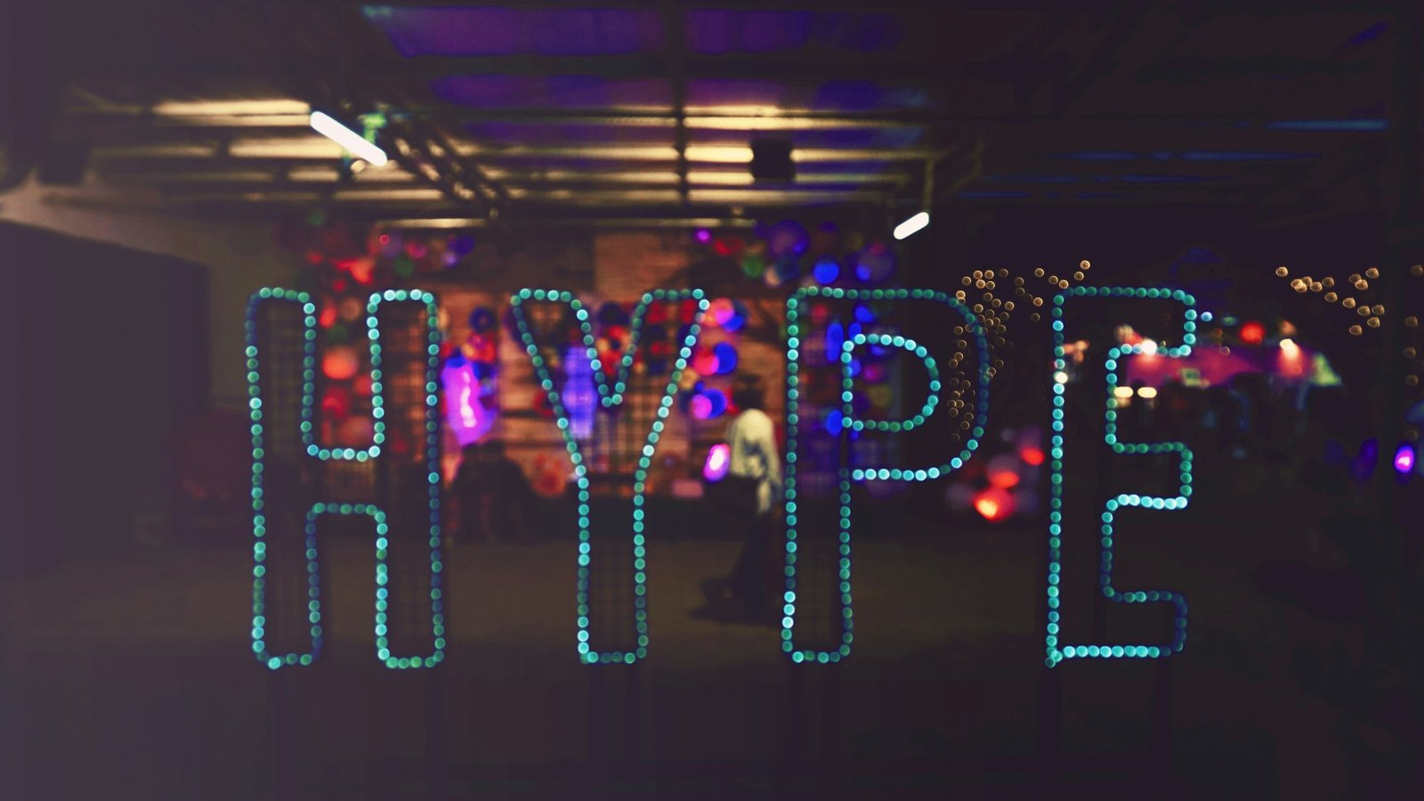The word HYPE spelled out in glowing lights in a dark room.